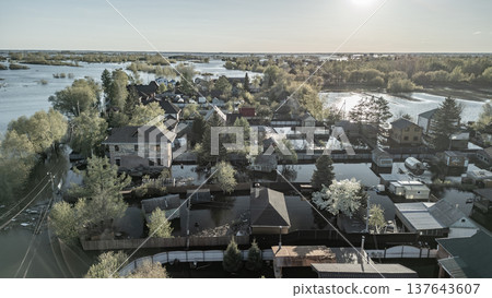 Spring flood disaster with fully submerged houses, flooded roads and overflowing waterways. The footage shows the dramatic impact of heavy rainfall and rising water levels on residential areas 137643607