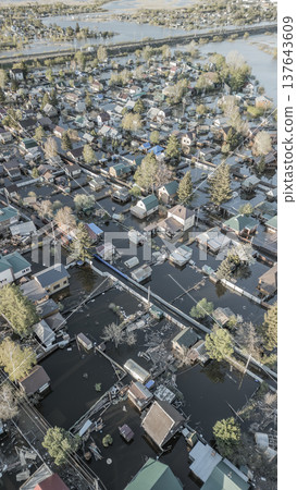 Spring flood disaster with fully submerged houses, flooded roads and overflowing waterways. The footage shows the dramatic impact of heavy rainfall and rising water levels on residential areas 137643609