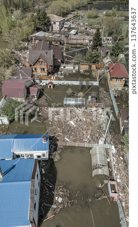 Spring flood disaster with fully submerged houses, flooded roads and overflowing waterways. The footage shows the dramatic impact of heavy rainfall and rising water levels on residential areas 137643637