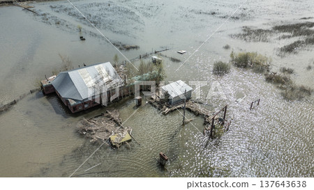 Spring flood disaster with fully submerged houses, flooded roads and overflowing waterways. The footage shows the dramatic impact of heavy rainfall and rising water levels on residential areas 137643638