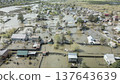 Spring flood disaster with fully submerged houses, flooded roads and overflowing waterways. The footage shows the dramatic impact of heavy rainfall and rising water levels on residential areas 137643639