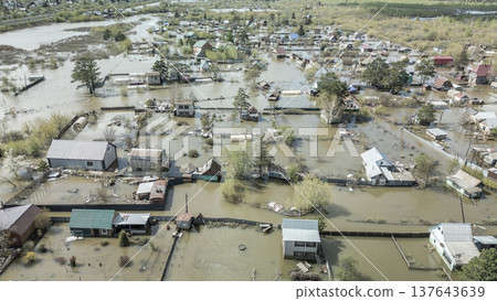 Spring flood disaster with fully submerged houses, flooded roads and overflowing waterways. The footage shows the dramatic impact of heavy rainfall and rising water levels on residential areas 137643639