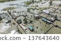 Spring flood disaster with fully submerged houses, flooded roads and overflowing waterways. The footage shows the dramatic impact of heavy rainfall and rising water levels on residential areas 137643640
