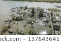 Spring flood disaster with fully submerged houses, flooded roads and overflowing waterways. The footage shows the dramatic impact of heavy rainfall and rising water levels on residential areas 137643641