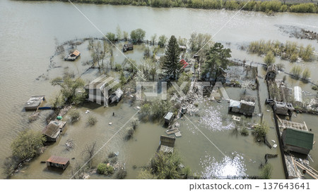 Spring flood disaster with fully submerged houses, flooded roads and overflowing waterways. The footage shows the dramatic impact of heavy rainfall and rising water levels on residential areas 137643641