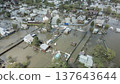Spring flood disaster with fully submerged houses, flooded roads and overflowing waterways. The footage shows the dramatic impact of heavy rainfall and rising water levels on residential areas 137643644
