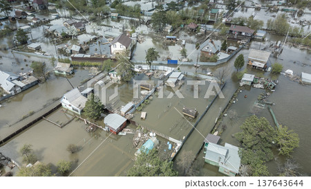 Spring flood disaster with fully submerged houses, flooded roads and overflowing waterways. The footage shows the dramatic impact of heavy rainfall and rising water levels on residential areas 137643644