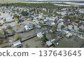 Spring flood disaster with fully submerged houses, flooded roads and overflowing waterways. The footage shows the dramatic impact of heavy rainfall and rising water levels on residential areas 137643645