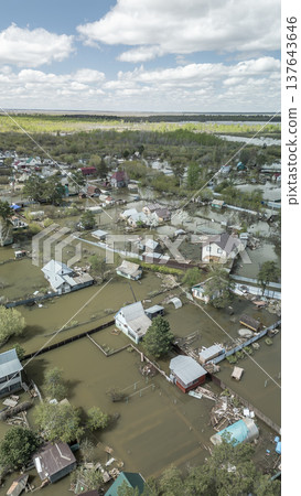 Spring flood disaster with fully submerged houses, flooded roads and overflowing waterways. The footage shows the dramatic impact of heavy rainfall and rising water levels on residential areas Spring flood disaster with fully submerged houses, flooded roads and overflowing waterways. The footage shows the dramatic impact of heavy rainfall and rising water levels on residential areas 137643646