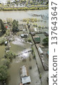Spring flood disaster with fully submerged houses, flooded roads and overflowing waterways. The footage shows the dramatic impact of heavy rainfall and rising water levels on residential areas 137643647