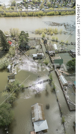 Spring flood disaster with fully submerged houses, flooded roads and overflowing waterways. The footage shows the dramatic impact of heavy rainfall and rising water levels on residential areas 137643647