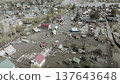 Spring flood disaster with fully submerged houses, flooded roads and overflowing waterways. The footage shows the dramatic impact of heavy rainfall and rising water levels on residential areas 137643648