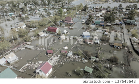 Spring flood disaster with fully submerged houses, flooded roads and overflowing waterways. The footage shows the dramatic impact of heavy rainfall and rising water levels on residential areas 137643648