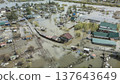 Spring flood disaster with fully submerged houses, flooded roads and overflowing waterways. The footage shows the dramatic impact of heavy rainfall and rising water levels on residential areas 137643649