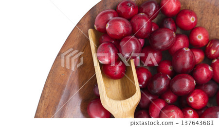 Fresh cranberries in a wooden bowl with a small wooden scoop Fresh cranberries in a wooden bowl with a small wooden scoop 137643681