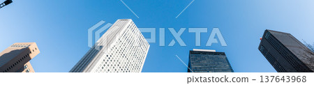 新宿的摩天大樓在藍天的映襯下拔地而起,象徵商業的成長和未來。 新宿的摩天大樓在藍天的映襯下拔地而起,象徵商業的成長和未來。 137643968