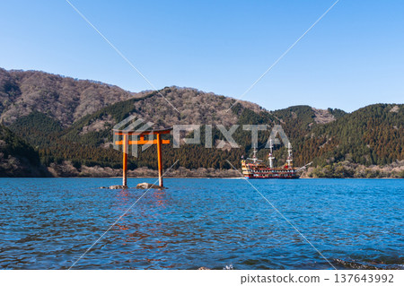 A view of the underwater torii gate of Kuzuryu Shrine standing on the surface of Lake Ashi in Hakone, along with a sightseeing boat. 137643992