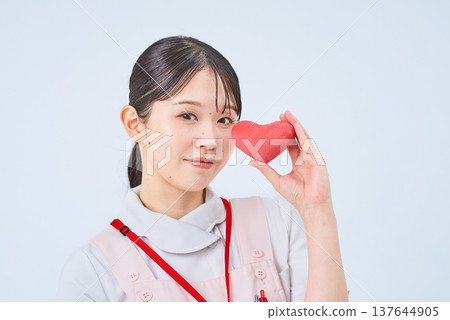 一個穿著白大褂和圍裙的年輕女子 一個穿著白大褂和圍裙的年輕女子 137644905