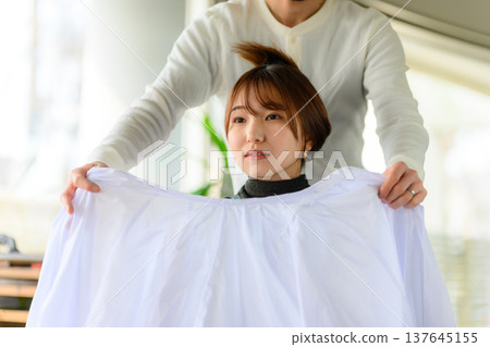 理髮師正在披上理髮披肩。 137645155