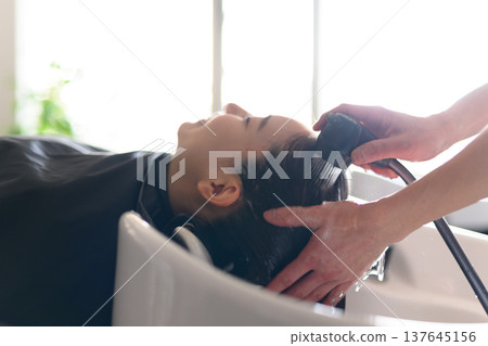 Washing your hair at the shampoo station in a hair salon 137645156