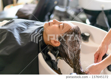 一位女士在洗髮站洗頭。 137645172