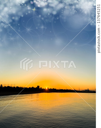 The sunset reflected on the water's surface, against an orange sky and a calm sea. 137645251