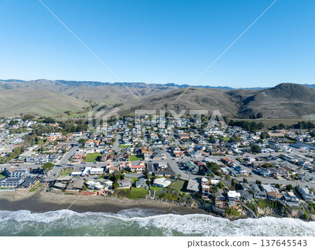 Aerial view of Cayucos, California USA, Pier, Ocean Ave and Shoreline Beach with Green Hills in San Luis Obispo County 137645543