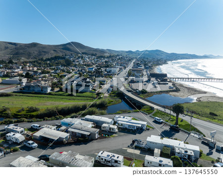 Aerial view of Cayucos, California USA, Pier, Ocean Ave and Shoreline Beach with Green Hills in San Luis Obispo County 137645550