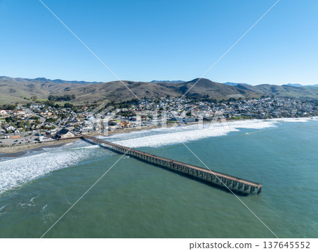 Aerial view of Cayucos, California USA, Pier, Ocean Ave and Shoreline Beach with Green Hills in San Luis Obispo County Aerial view of Cayucos, California USA, Pier, Ocean Ave and Shoreline Beach with Green Hills in San Luis Obispo County 137645552