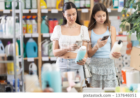 Woman with daughter scanning qr code for shampoo or shower gel Woman with daughter scanning qr code for shampoo or shower gel 137646051