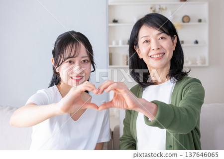 母女倆看著鏡頭，比出一個心形。 137646065