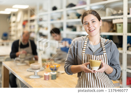 Young woman holding finished ceramic piece Young woman holding finished ceramic piece 137646077
