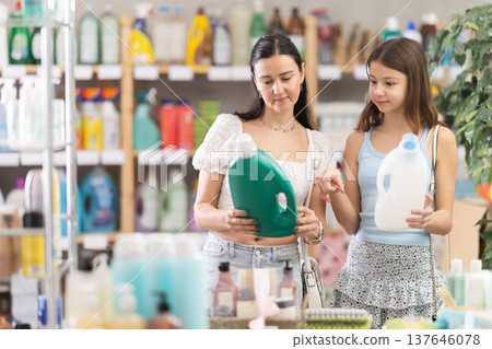 Woman with daughter choosing detergent in store 137646078