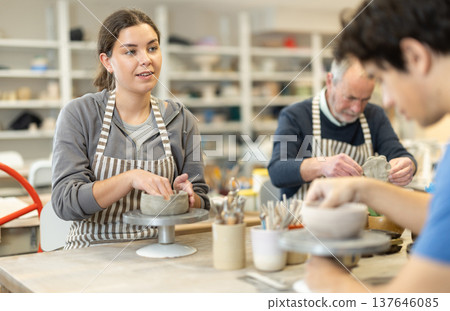 Young woman and man and elderly man crafting ceramics 137646085