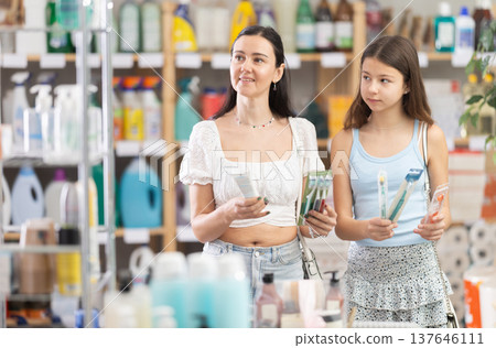 Mom with teen girl view trademark sign on label, pick eco friendly toothbrush Mom with teen girl view trademark sign on label, pick eco friendly toothbrush 137646111