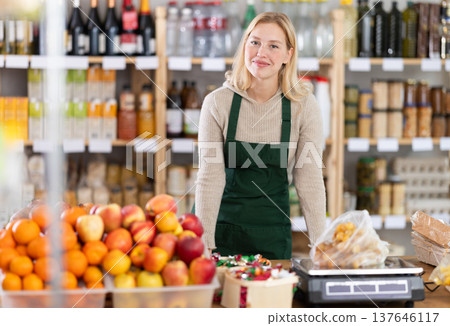 Young woman seller at counter in grocery store 137646117