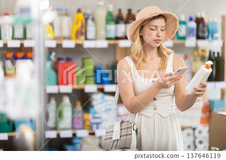 Girl buyer scans qr code on sunblock cream label 137646119