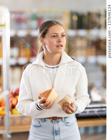 Young woman chooses cheese Young woman chooses cheese 137646134