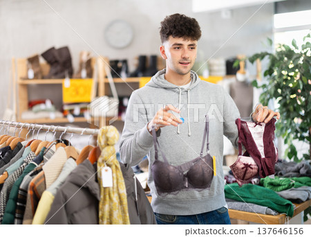 Young guy choosing bra in clothing store 137646156