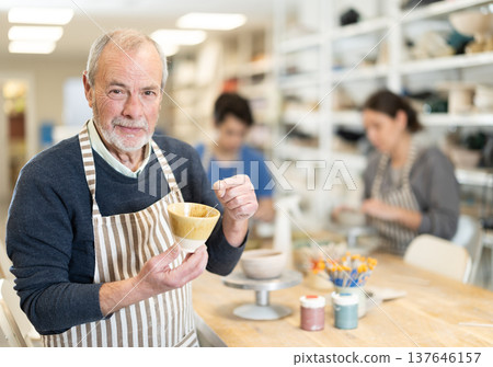 Eldery man holding finished ceramic piece 137646157