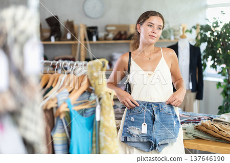 Young woman choosing denim shorts 137646190