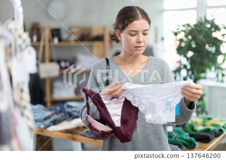 Uncertain young girl choosing panties in clothing store 137646200
