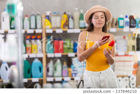 Girl buyer scans qr code on sunblock cream label 137646210