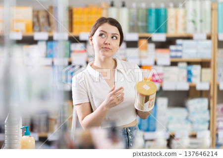 Young woman choosing baby formula in pharmacy 137646214