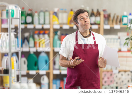 Anxious man seller with checklist in decorated store 137646246