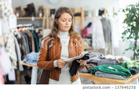 Female shopper selects socks in fashionable clothing boutique Female shopper selects socks in fashionable clothing boutique 137646258