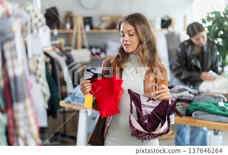 Uncertain young girl choosing panties in clothing store 137646264