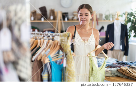 Fashionista girl near showcase examine goods, buying something clothing for summer. 137646327