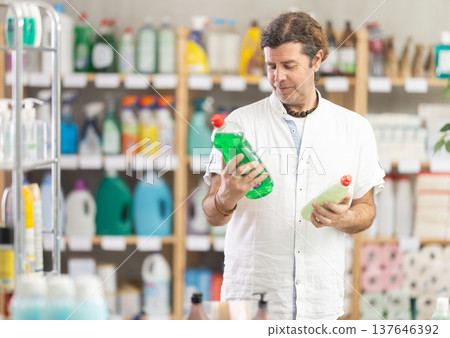 Adult man chooses dishwashing detergent in store 137646392