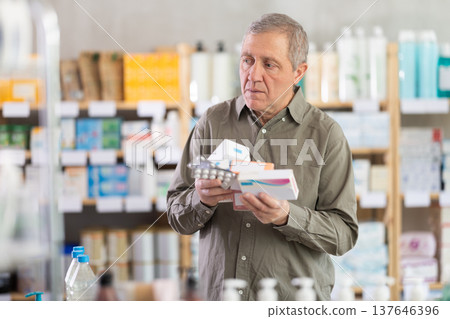 Elderly man with several packs of pills 137646396